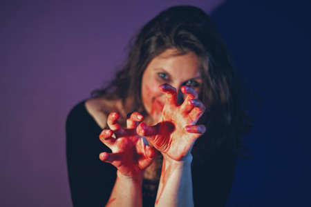 girl with scary make up on Halloween party. focus on bloody hands.の写真素材