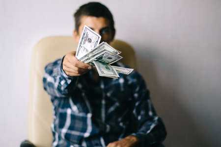 a young man throws money (dollars)