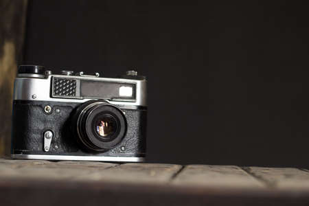 vintage old film camera opposite the black wall, copy spaceの写真素材