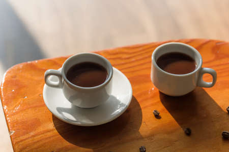 two white cups of black coffee on the tableの写真素材