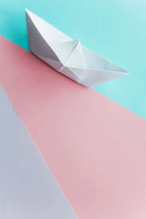origami paper boat on pastel background