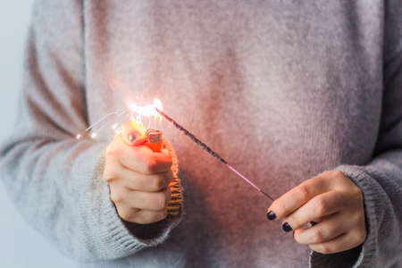girl in the grey sweater ignites the sparklerの写真素材