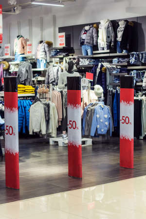 clothing store with anti thief gates with 50 procent sale inscriptions