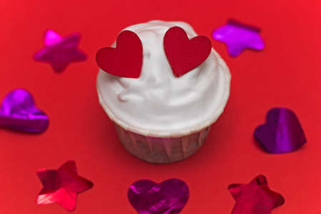 cute cupcake  with hearts and confetti red  backgroundの写真素材
