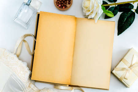 top view of rose , gift box,blush, perfume bottle and empty diary  with space for textの写真素材