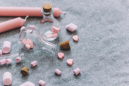bottle with pink chocolate hearts,marshmallows,candles gray knitted backgroundの写真素材