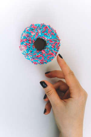 top view colorful donut and female handの写真素材