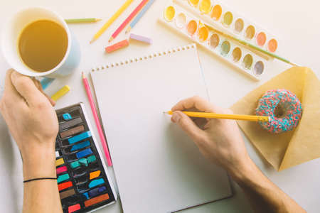 top view male hands working with pencil and blank sheet of paperの写真素材