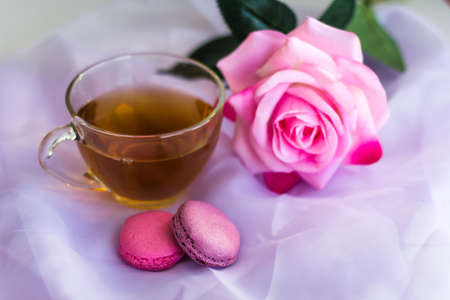 tea cup and macaroons on the table with  blurred roseの写真素材