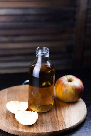 fresh drink in a glass bottle and apple slices wooden backgroundの写真素材