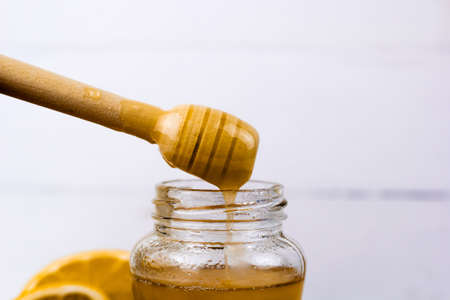 close up honey drains from a wooden stick