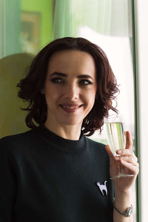 young beautiful brunette with a glass of sparkling wineの写真素材