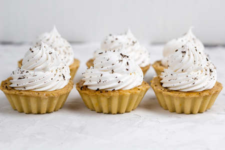 three cupcake with cream decorated with chocolate chips concrete backgroundの写真素材