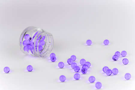 violet vitamins in a glass jar white backgroundの写真素材