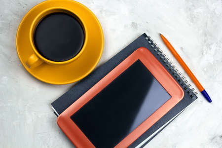 coffee cup,tablet,notebook and pen on a tableの写真素材