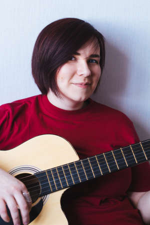 beautiful young woman playing guitarの写真素材