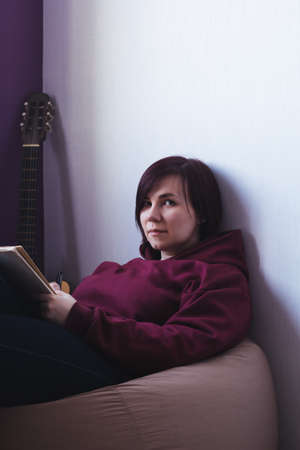 young creative woman sitting on a chair and compose a new songの写真素材