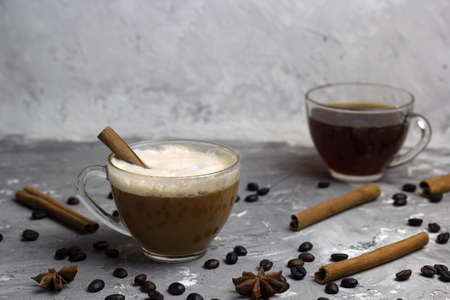 two cups of coffe, cinnamon sticks, coffee beans, anise stars