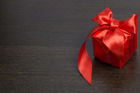 red gift box with red satin ribbon top view
