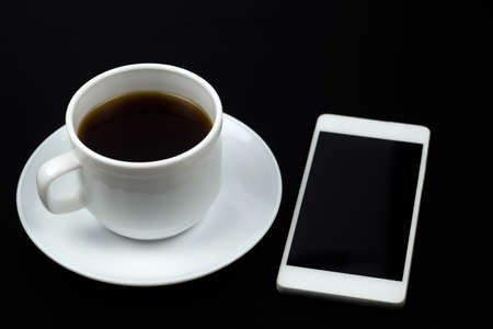 top view coffe cup and smartphone ona a black tableの写真素材