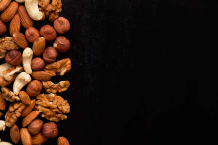 top view mix of nuts frame on a black tableの写真素材
