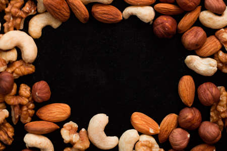 top view mix of nuts frame on a black tableの写真素材