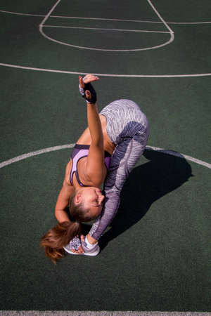 beautiful young athletic girl doing stretching outdoor on the basketball court, sports,  healthy lifestyle conceptの写真素材