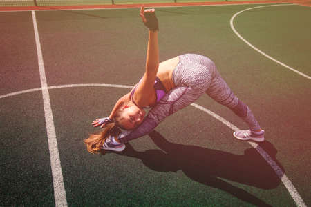beautiful young athletic girl doing stretching outdoor on the basketball court, sports,  healthy...