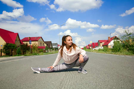 Young sporty woman getting ready to start running workout , warm up stretching  before  running outdoorsの写真素材
