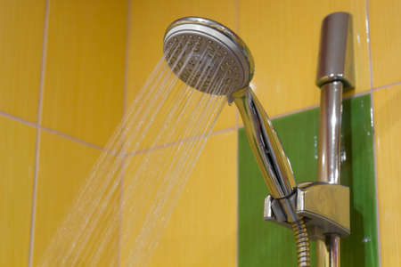 shower with water pressure, yellow tiles on the backgroundの写真素材