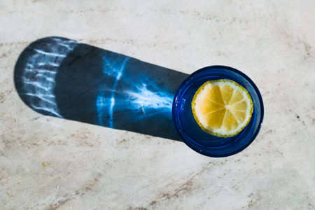 top view bright glass with drink and lemon slice, beautiful shadow on a stone marble table  ,detox,...