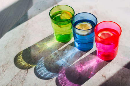 top view bright glass with drink and lemon slice, beautiful shadow on a stone marble table  ,detox, creativity,fashion conceptの写真素材
