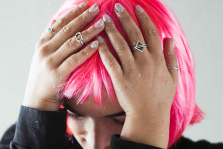 woman in pink wig touch her headの写真素材