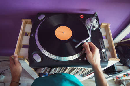 top view man puts a vinyl record in the playerの写真素材