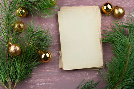 old empty paper sheets and fir green branches with christmas golden balls  top view brown shabby...