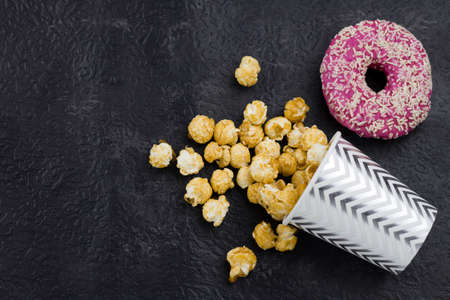 top view pop corn and donut  on a black background