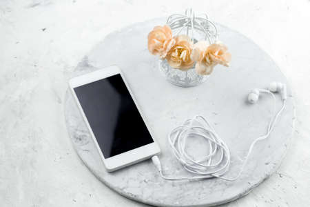 phone on a table with decorative cage and fresh flowers