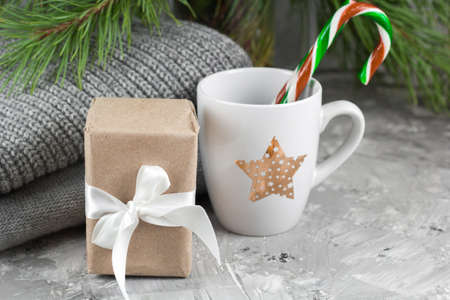 gift box , white cup, candy cane, sweaters and christmas tree branches