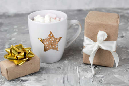 cute stylish cup with marshmallows and gift box concrete gray backgroundの写真素材
