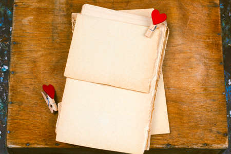 old empty paper sheets and cloth pins with hearts  top view wooden table mock up for st valentines...