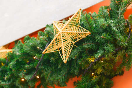 Christmas decorations with golden stars on orange wall background