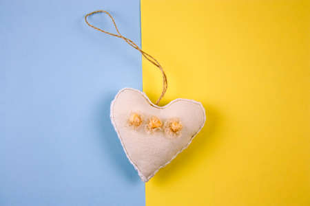 top view cute stuffed toy in form of heart on a blue and yellow background