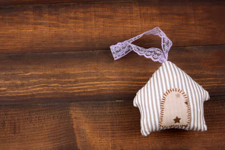 top view cute stripped stuffed toy in a shape of house on a wooden backgroundの写真素材