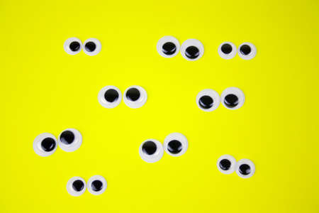googly eyes on yellow pastel background,top view flat layの写真素材
