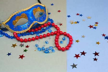 blue carnival mask and beads on green and blue backgroundの写真素材