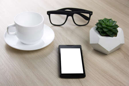 coffee cup, succulent and smartphone  on a wooden tableの写真素材