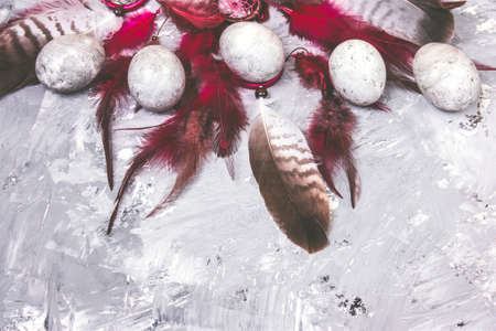 top view painted easter eggs with stone effect and bright feathers