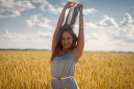 beautiful woman in silver dress on a fieldの写真素材
