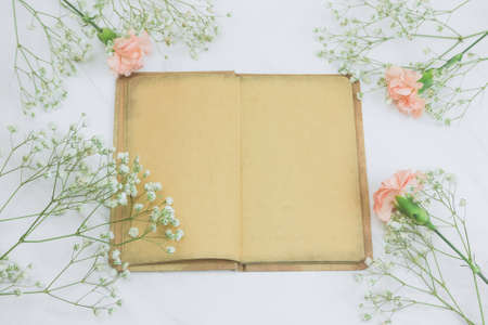 top viewvintage book with empty sheets and flowers on a marble backgroundの写真素材
