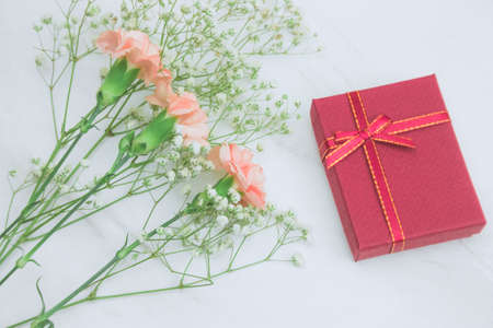 bouquet  of gypsophila and carnation  flowers and gift box on a marble table top view
